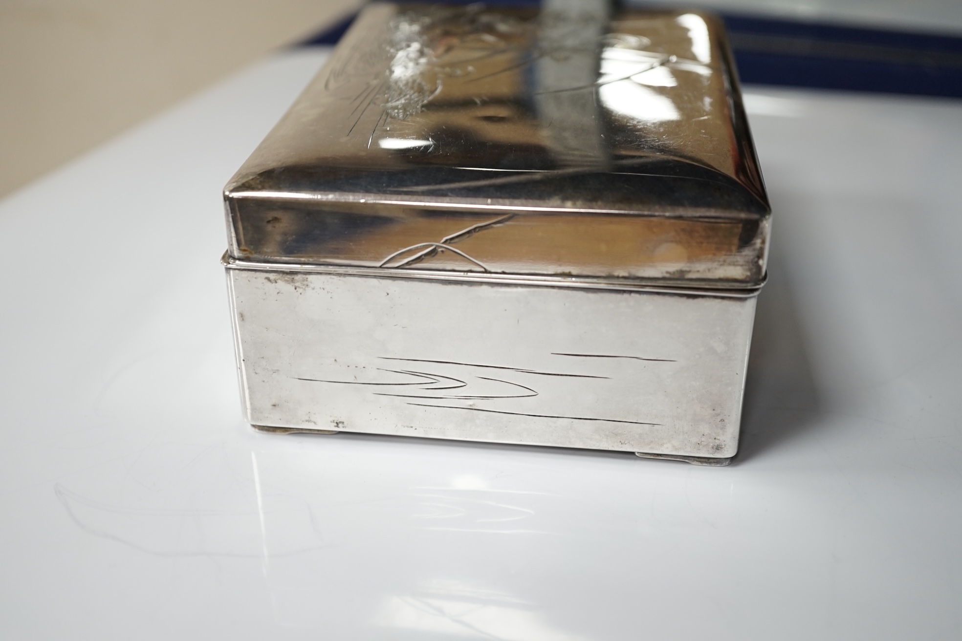 A Japanese white and yellow metal mounted rectangular cigarette box, engraved with birds and reeds, signed to the base, 14.2cm. Condition - fair